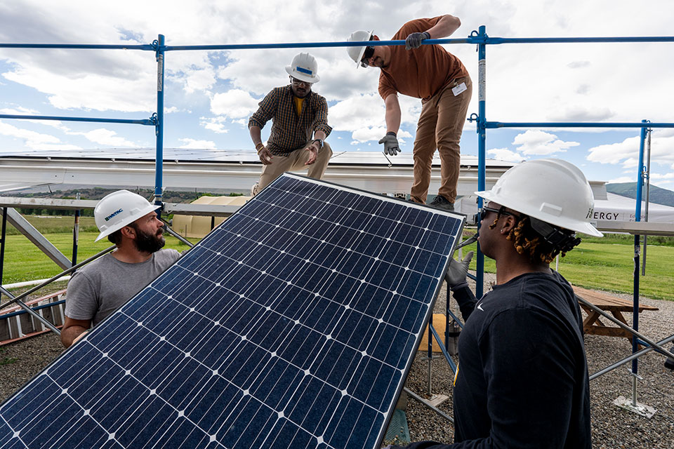 Workers collaborating to install a solar panel
